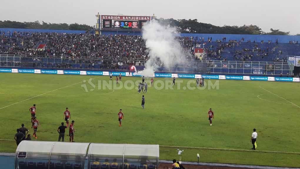 Kekecewaan atas performa tim dilakukan Aremania dengan membakar petasan dan flare, hingga membuat laga Arema FC vs Bali United sempat terhenti 3 menit, Senin (16/12/19). Copyright: © Ian Setiawan/INDOSPORT