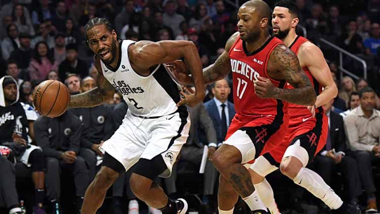 Bintang LA Clippers, Kawhi Leonard (kiri) mendapat penjagaan ketat dari dua pemain Houston Rockets dalam pertandingan NBA. Copyright: © Harry How/GettyImages