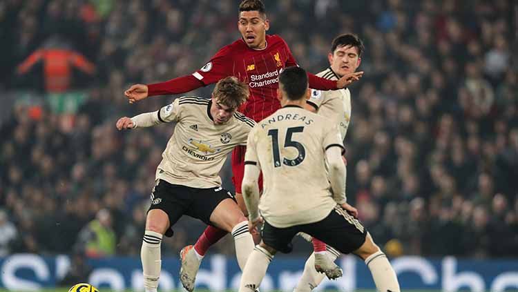 Roberto Firmino (tengah) berada dalam kawalan tiga pemain Man United, Minggu (19/01/20). Copyright: © Michael Regan/Getty Images