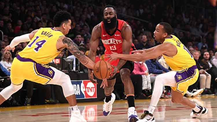 Pemain megabintang NBA, James Harden (tengah-Houston Rockets) dijaga ketat oleh dua pemain LA Lakers. Copyright: © Kevork Djansezian/Getty Images