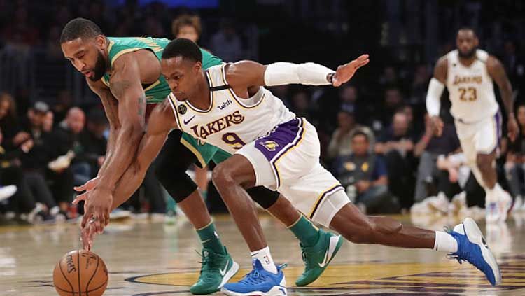 Perebutan bola terjadi antara bintang basket LA Lakers, Rajon Rondo (kanan), dengan penggawa Boston Celtics, Brad Wanamaker, dalam laga NBA 2019-2020. Copyright: © Katelyn Mulcahy/Getty Images