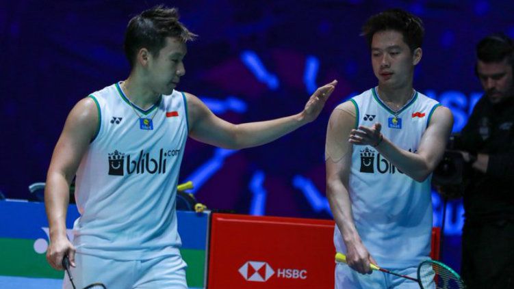 Marcus Gideon terlihat lesu saat berada di podium All England bersama Kevin Sanjaya, lantaran gagal menjadi juara ajang Super 1000 tersebut. Copyright: © Twitter @INABadminton