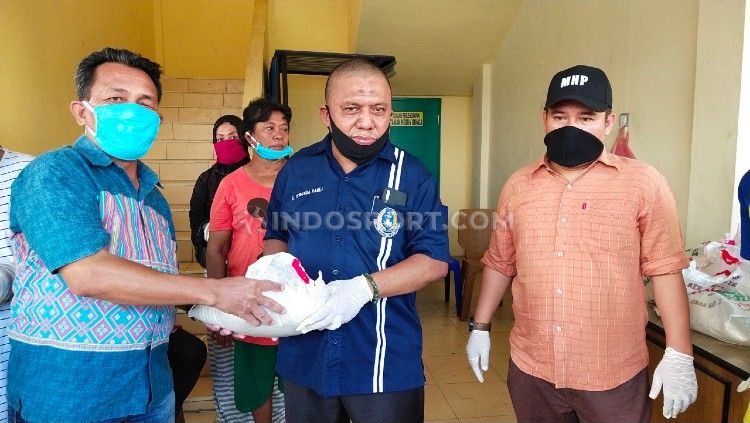Ketua Askot PSSI Medan, Iswanda Ramli (tengah), membagikan bantuan beras kepada masyarakat akibat dampak dari virus Corona. Copyright: © Aldi Aulia Anwar/INDOSPORT