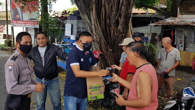 Pemain Sulut United turun ke jalan membagikan masker kepada masyarakat Kota Manado. Copyright: © Official Sulut United