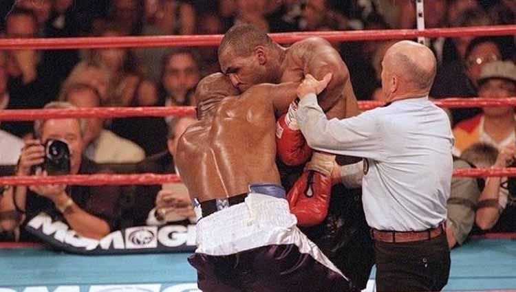 Aksi gigitan Mike Tyson ke telinga Evander Holyfield pada ronde ketiga, dalam pertarungan tinju kelas berat, (28/06/1997). Copyright: © GEORGE TIEDEMANN/GETTY IMAGES