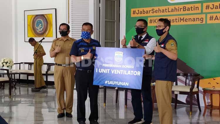 Komisaris PT PBB, Umuh Muchtar secara simbolis menyerahkan bantuan berupa 50.000 masker, 2500 alat pelindung diri (APD) dan 1 unit ventilator kepada Ketua Gugus Tugas Percepatan Penanggulangan Covid-19 Jawa Barat, Ridwan Kamil di Gedung Pakuan. Copyright: © Arif Rahman/INDOSPORT