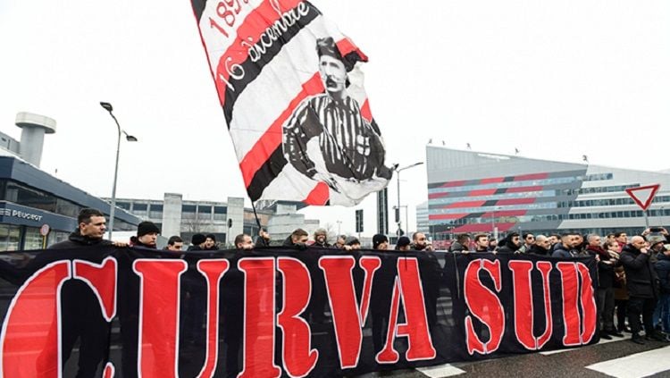 Para pendukung garis keras AC Milan, Curva Sud, membawa bendera Herbert Kilpin di dekat casa MIlan. Copyright: © acmilan