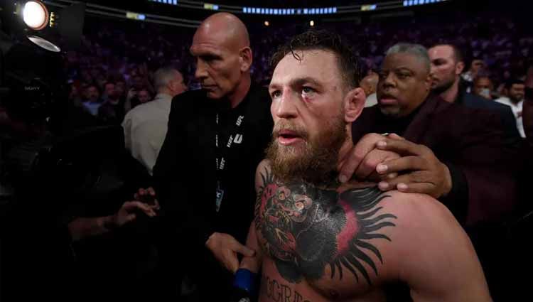 McGregor meninggalkan arena dengan pengawalan ketat di sekelilingnya. Copyright: © Stephen McCarthy/Sportsfile via Getty Images