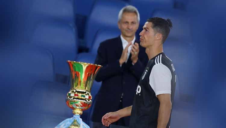 Cristiano Ronaldo pergi melewati trofi Coppa Italia dengan wajah kecewa usai laga Napoli vs Juventus. Copyright: © Marco Rosi/Getty Images