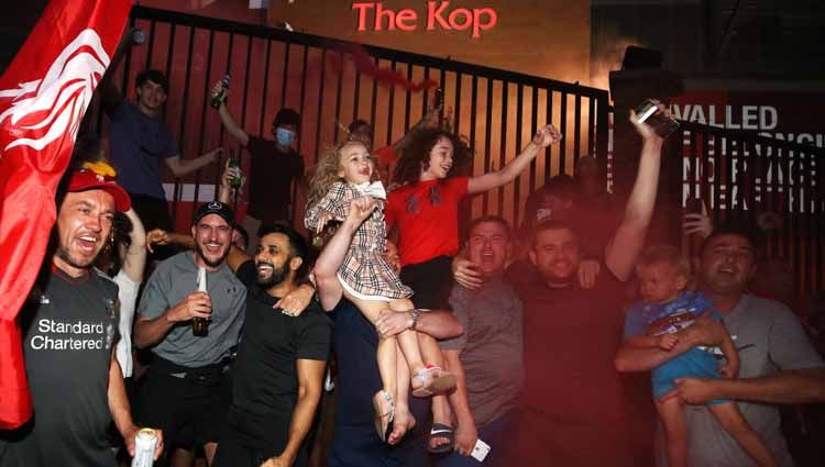 Ilustrasi - penggemar Liverpool saat melakukan selebrasi. Foto: Martin Rickett/PA Images via Getty Images. Copyright: © Martin Rickett/PA Images via Getty Images