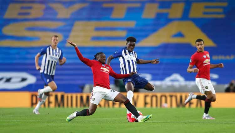 Pemain Manchester United, Aaron Wan-Bissaka, melakukan tekel pada Yves Bissouma. Copyright: © Alastair Grant Pool via Getty Iamges