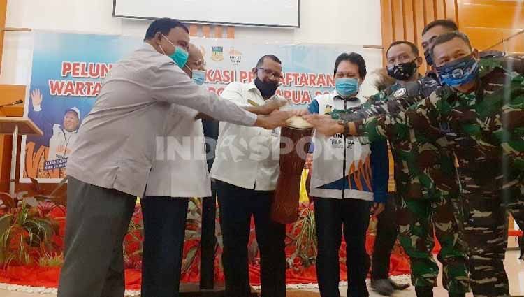 Asisten Bidang Perekonomian dan Kesejahteraan Rakyat Sekda Papua, Muhammad Musa'ad (tengah) bersama Ketua Harian PB PON, Yunus Wonda saat menabuh tifa peluncuran aplikasi pendaftaran wartawan PON XX. Copyright: © Sudjarwo/INDOSPORT