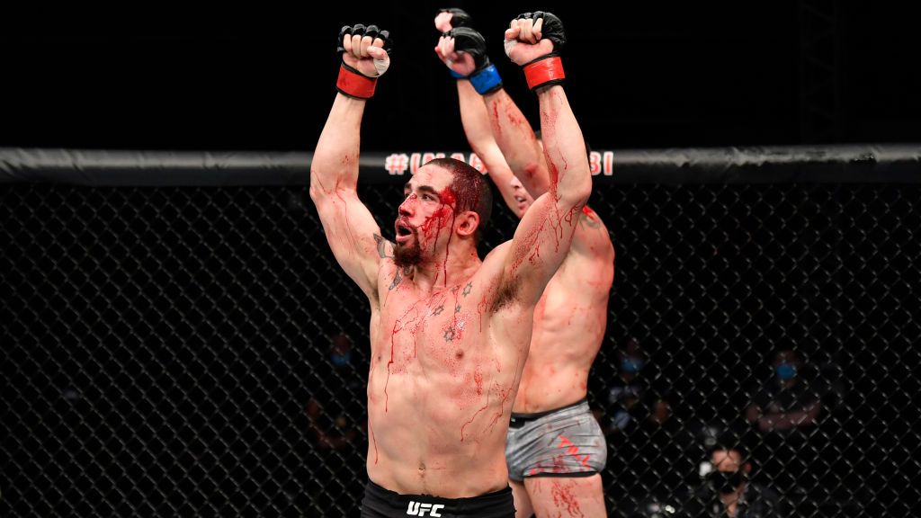 Petarung Mixed Martial Arts (MMA), Robert Whittaker berhasil mengalahkan lawannya, Darren Till di UFC Fight Island, meski tubuhnya harus berlumuran darah. Copyright: © Jeff Bottari/Zuffa LLC via Getty Images