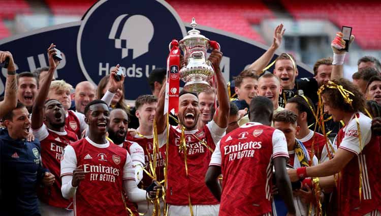 Selebrasi Pierre-Emerick Aubameyang (Arsenal) mengangkat Piala FA bersama rekan-rekan setimnya usai kalahkan Chelsea. Copyright: © Adam Davy/Pool via Getty Images