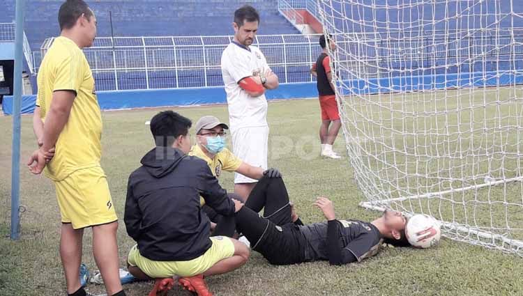 Kurniawan Kartika Ajie mendapat perawatan usai mendapat cedera saat latihan perdana Arema FC di Stadion Kanjuruhan, Senin (03/08/20). Copyright: © Ian Setiawan/INDOSPORT