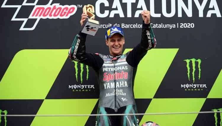 Fabio Quartararo angkat tropi kemenangannya di atas podium di MotoGP Moto Grand Prix de Catalunya, Minggu (27/09/2020). Copyright: © LLUIS GENE/AFP via Getty Images
