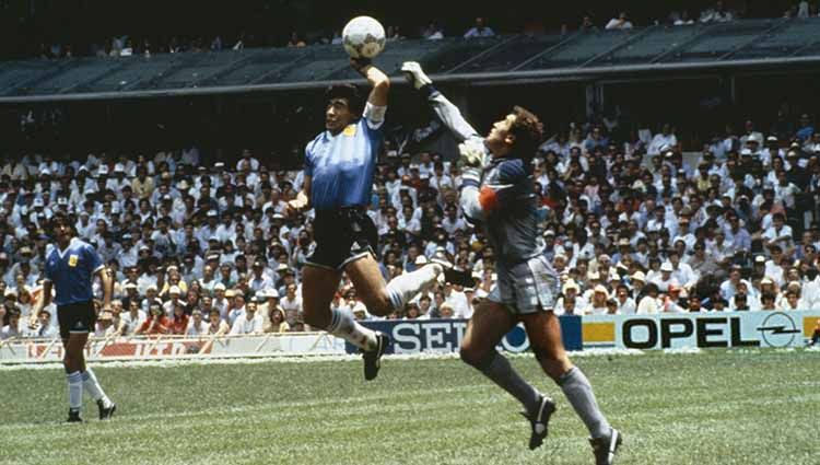Diego Maradona (tengah), saat mencetak gol menggunakan tangannya ke gawang Inggris yang dijaga Peter Shilton (kanan), pada babak perempat final Piala Dunia 1986 Meksiko. Copyright: © Bob Thomas Sports Photography via Getty Images