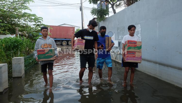 Pemain PSIS Hari Nur Yulianto (kaos hitam) saat mengantarkan bantuan bagi korban banjir. Copyright: © Alvin Syaptia/INDOSPORT