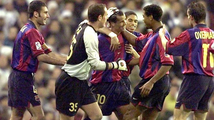 Pemain Barcelona mengerubungi Rivaldo usai membobol gawang Real Madrid dalam pertandingan LaLiga Spanyol, 3 Maret 2001. Copyright: © AFP