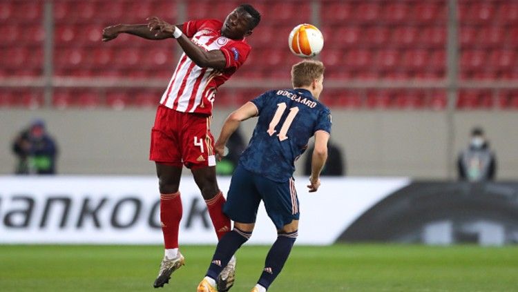 Mohamed Camara (kiri) dan Martin Odegaard (kanan) dalam laga lanjutan babak 16 besar Liga Europa 2020/21 antara Olympiakos vs Arsenal. Copyright: © (Photo by Eurokinissie/BSR Agency/Getty Images)