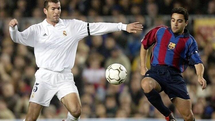 Gelandang Barcelona, Xavi Hernandez, berduel dengan Zinedine Zidane dalam pertandingan LaLiga Spanyol kontra Real Madrid, 16 Maret 2002. Copyright: © Sphera Sports Real Madrid