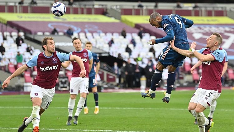 Pemain Arsenal, Alexandre Lacazette, mencetak gol ke gawang West Ham United pada laga lanjutan Premier League di London Stadium, Minggu (21/3/2021). Copyright: © Justin Tallis/Getty Images