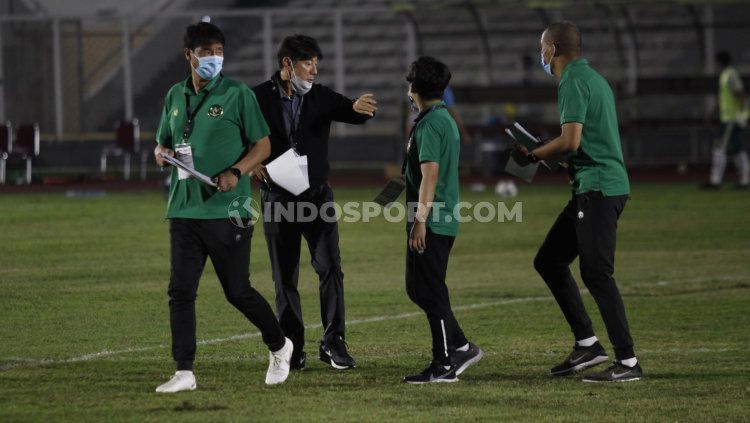 Pelatih Shin Tae-yong saat berbicara dengan Nova Araianto (kanan). Copyright: © Herry Ibrahim/INDOSPORT