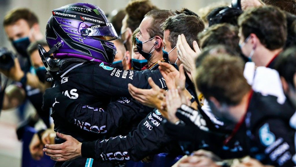 Pembalap Mercedes asal Inggris, Lewis Hamilton, merayakan bersama tim setelah memenangi balpan GP Bahrain di Bahrain International Circuit, Sakhir, Minggu (28/3/2021). Copyright: © Mark Thompson/Getty Images