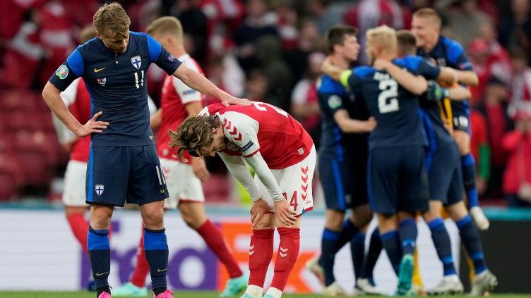 Rasmus Schuller sedang mencoba menghibur Mathias Jensen yang menggantikan Christian Eriksen dalam laga Euro 2020 Denmark vs Finlandia Copyright: © Martin Meissner - Pool/Getty Images