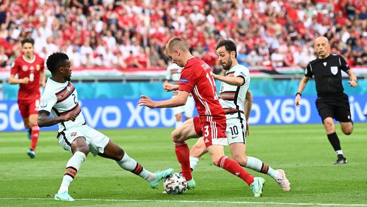 Andras Schaefer berduel dengan Nelson Semedo dan Bernardo Silva di laga Hungaria vs Portugal. Copyright: © Attila Kisebenedek/Getty Images