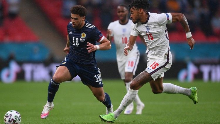 Duel Che Adams (Skotlandia) melawan Tyrone Mings (Inggris) di laga kedua grup D Euro 2020. Copyright: © Laurence Griffiths/Getty Images