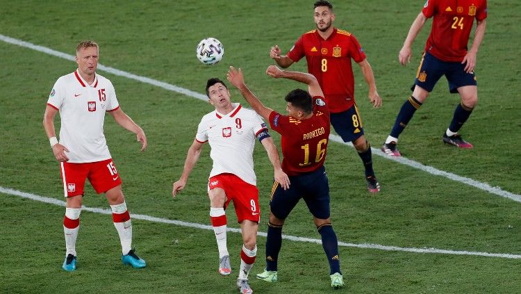 Robert Lewandowski berduel dengan Rodrigo di laga Euro 2020 Spanyol vs Polandia. Copyright: © Jose Manuel Vidal/Getty Images