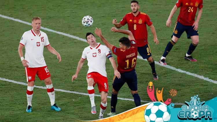 Robert Lewandowski berduel dengan Rodrigo di laga Euro 2020 Spanyol vs Polandia. Copyright: © Jose Manuel Vidal/Getty Images