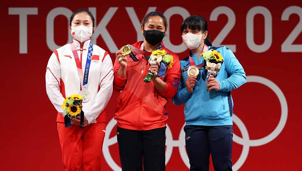 Peraih medali emas angkat besi, Hidilyn Diaz dari Filipina berpose bersama Liao Qiuyun dari China dan Zulfiya Chinshanlo dari Kazakhstan. Copyright: © REUTERS/Edgard Garrido