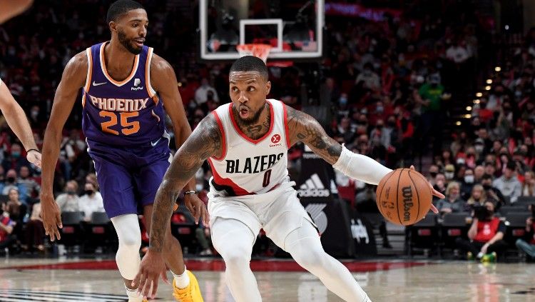 Damian Lillard (Blazers) mencoba lepas dari kawalan Mikal Bridges (Suns) di laga NBA 2021-2022, Minggu (24/10/21). Copyright: © Steve Dykes-USA TODAY Sports/REUTERS