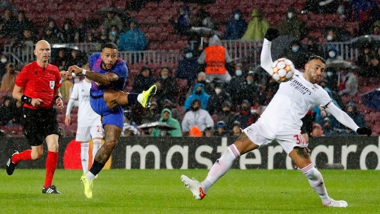 Memphis Depay melepaskan tembakan keras di laga Barcelona vs Benfica (24/11/21). Copyright: © REUTERS/Nacho Doce