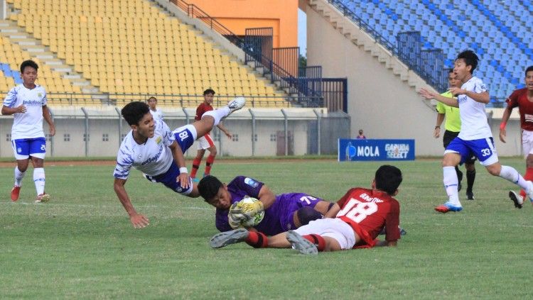 Pemain Persib U-18 terjatuh saat duel dengan kiper Bali United U-18, pada laga final EPA 2021 di Stadion Si Jalak Harupat, Kabupaten Bandung, Kamis (25/11/21). Copyright: © Arif Rahman/INDOSPORT