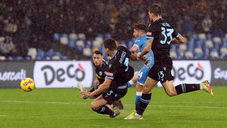 Dries Mertens (Napoli) melepaskan tembakan yang berbuah gol di tengah kepungan pemain Lazio (29/11/21). Copyright: © REUTERS/Ciro De Luca