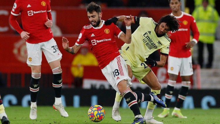 Bruno Fernandes berduel dengan Mohamed Elneny di laga Manchester United vs Arsenal (03/12/21). Copyright: © REUTERS/Phil Noble