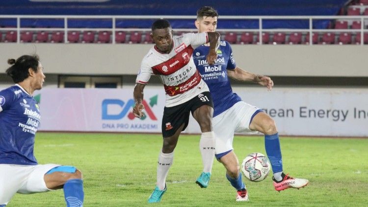 Perebutan bola penyerang Madura United, David Laly dengan bek Persib Bandung, Nick Kuippers. Copyright: © Nofik Lukman Hakim/INDOSPORT