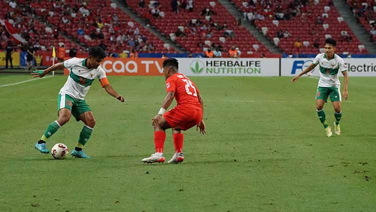 Pemain Singapura tampak fokus berusaha untuk menggagalkan aksi Asnawi Mangkualam di Piala AFF lalu. Copyright: © PSSI