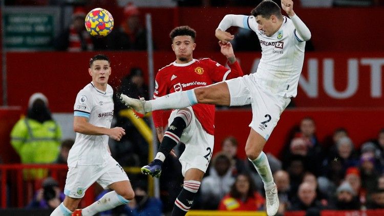 Jadon Sancho berduel dengan Matthew Lowton di laga Manchester United vs Burnley, Jumat (31/12/21). Copyright: © REUTERS/Phil Noble