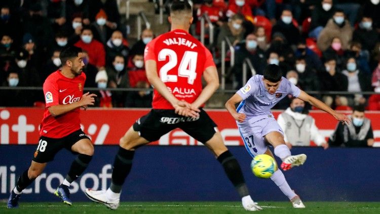 Pemain muda Barcelona, Ilias Akhomach melepaskan tembakan ke gawang Mallorca, Senin (03/01/22). Copyright: © REUTERS/Nacho Doce