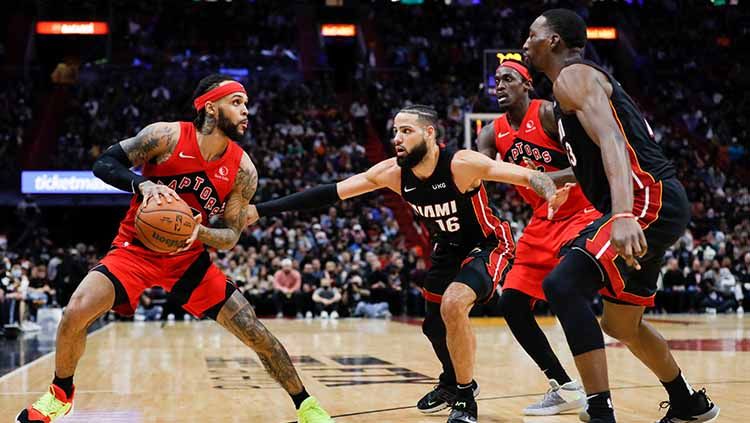 Pemain Guard Toronto Raptors Gary Trent Jr. (33) tampak fokus membawa bola dan berusaha melewati pemain Miami Heat Caleb Martin (16) di FTX Arena. Copyright: © Sam Navarro-USA TODAY Sports/Reuters