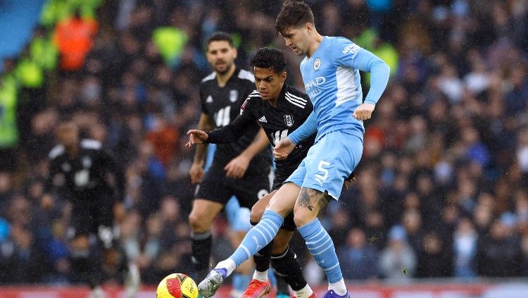 John Stones berduel dengan Fabio Carvalho (tengah) di laga Piala FA Man City vs Fulham (05/02/22). (Foto: Reuters/Jason Cairnduff) Copyright: © Reuters/Jason Cairnduff