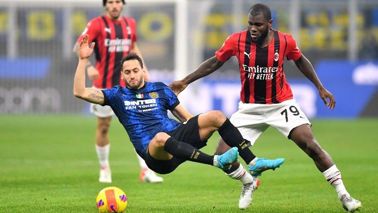 Hakan Calhanoglu berduel dengan Franck Kessie di laga Inter Milan vs AC Milan (06/02/22). (Foto: REUTERS/Daniele Mascolo) Copyright: © REUTERS/Daniele Mascolo