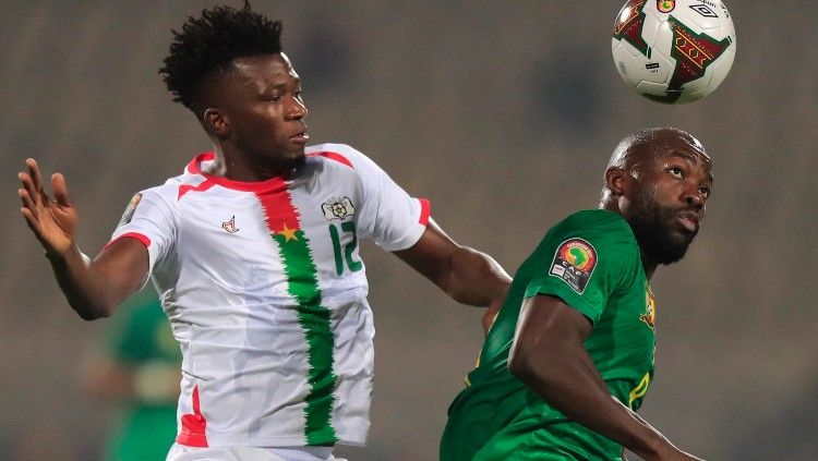 Edmond Tapsoba (kiri) berduel dengan Stephane Bahoken di laga Piala Afrika 2021 Burkina Faso vs Kamerun (06/02/22). (Foto: REUTERS/Thaier Al-Sudani) Copyright: © REUTERS/Thaier Al-Sudani