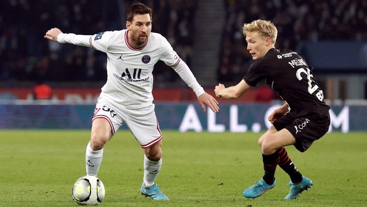 Lionel Messi (kiri) mencoba keluar dari tekanan lawan di laga PSG vs Rennes (12/02/22). (Foto: REUTERS/Benoit Tessier) Copyright: © REUTERS/Benoit Tessier