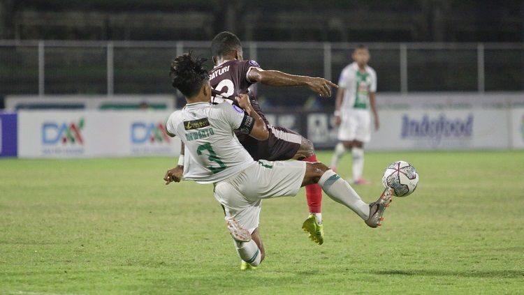 Winger PSM Makassar, Yakob Sayuri, berduel dengan kapten PSS Sleman, Bagus Nirwanto, pada pekan ke-28 BRI Liga 1 2021/22. (Foto: Official PSM Makassar) Copyright: © Foto: Official PSM Makassar