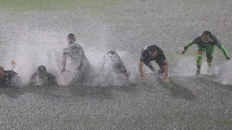 Selebrasi para pemain Persib Bandung memanfaatkan genangan air di Stadion Ngurah Rai, Denpasar usai mengalahkan Persiraja pada pekan ke-29 Liga 1. Copyright: © Nofik Lukman Hakim/INDOSPORT